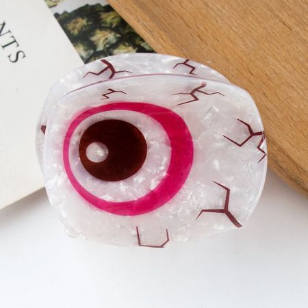 Eine rosa böse Augen Haarklammer im Detail gezeigt.