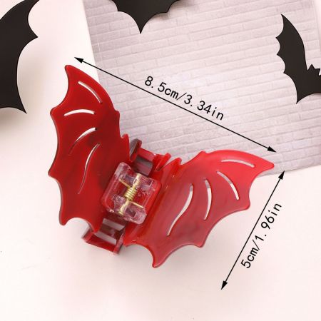 Prise de vue détaillée du clip à cheveux en forme de chauve-souris rouge sur fond blanc.