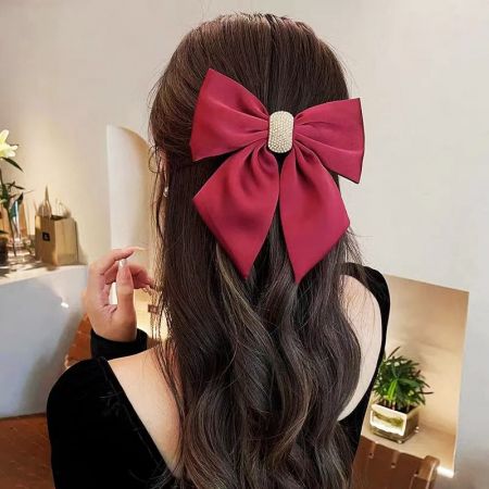 Toma de producto del clip para el cabello con lazo rojo, enfatizando su rico color y tela de calidad.