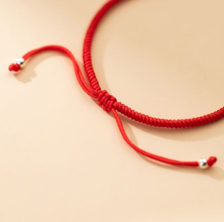 Detailed shot of the red cord 925 Sterling Silver Bamboo Rope Bracelet, showing the intricate sliding knot closure and silver bead details.