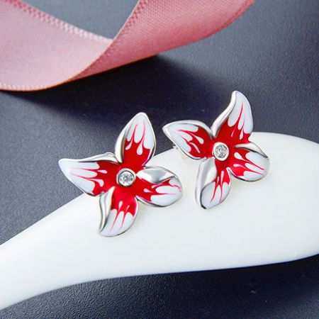 Un'altra prospettiva degli orecchini argentati floreali rossi, evidenziando il design a cinque petali.
