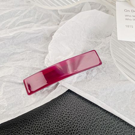 A stylish solid red rectangle hair barrette clip.