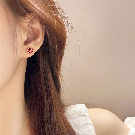 A close-up view of the mini red rose stud earring being worn, showing its scale and appearance.