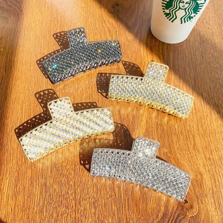 Metal Alloy Crystal Rhinestone Hair Claw Clips - A set of five large metal alloy hair claw clips, studded with sparkling rhinestones in silver and gold, elegantly arranged on a wooden surface.