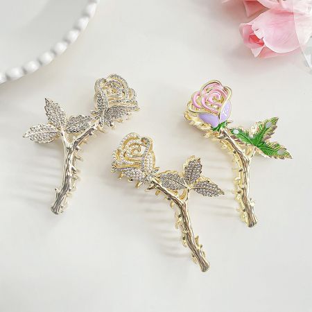 Elegantes clips para el cabello en forma de rosa de aleación metálica. - Un conjunto de tres elegantes clips para el cabello en forma de rosa en varios acabados metálicos, mostrando su intrincado diseño floral.