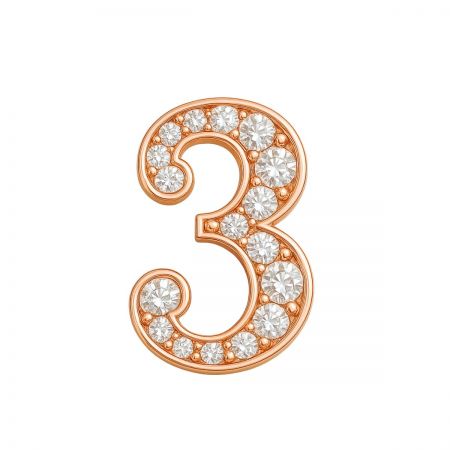 Primer plano de un broche personalizado con el número 3 en oro rosa con detalles de cristal.