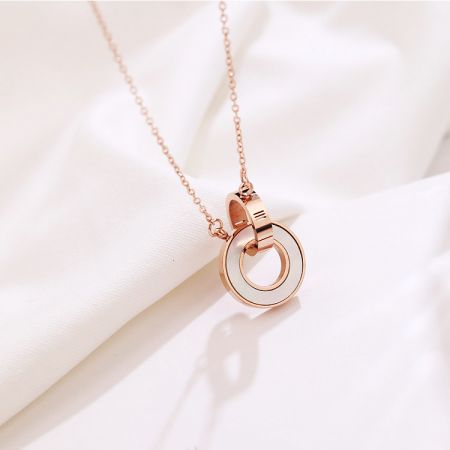 Detailed view of the hinged double-circle pendant on the rose gold necklace.