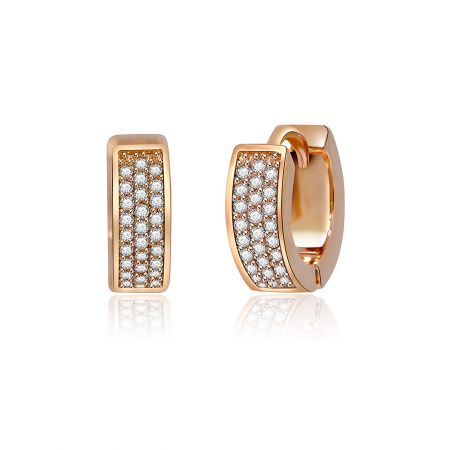 Primo piano dettagliato dell'orecchino huggie in oro rosa, evidenziando le brillanti pietre in zirconia cubica e la finitura lucida.