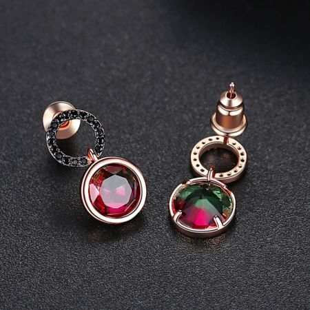 Une vue détaillée des boucles d'oreilles en cercle avec émail rouge, mettant en valeur la finition en or rose et le sertissage de pierres précieuses.