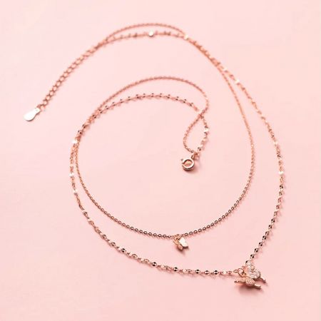 Elegant rose gold layered butterfly necklace with multiple charms.