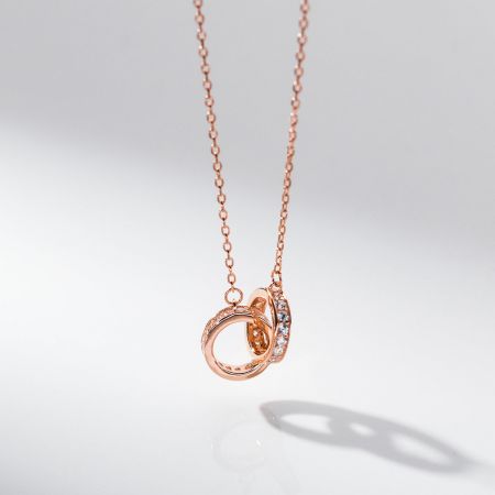 Primer plano del collar de colgante de círculo entrelazado de oro rosa.