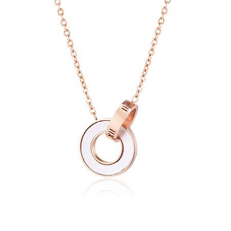Ketting met ringen van roestvrij staal. - Close-up van de ketting met ringen van roestvrij staal in roségoud, met een in elkaar grijpende hanger met twee ringen en witte emaille inleg.