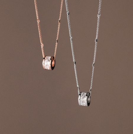 Collar de CZ en forma de baguette de plata esterlina 925 - Un par de collares de CZ en forma de baguette de plata esterlina 925, uno con un acabado de plata pulida y el otro con un acabado de oro rosa cálido, exhibidos uno al lado del otro.