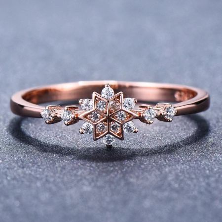 The Starlight Sparkle snowflake ring in a warm rose gold finish, adorned with sparkling diamonds.