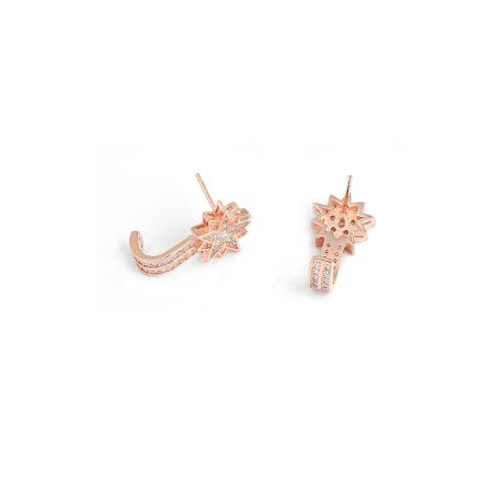 Prise de vue détaillée des pierres en zircon cubique sur les boucles d'oreilles en or rose en forme d'étoile.