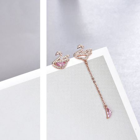 Elegant rose gold swan-shaped earrings with delicate pink and clear gemstones.