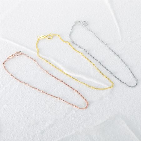 Bulk 925 sterling zilveren mini ronde kralenkettingarmband - Een set van drie 925 sterling zilveren mini ronde kralenkettingarmbanden in roségoud, geelgoud en zilveren afwerkingen, weergegeven op een schone witte achtergrond.