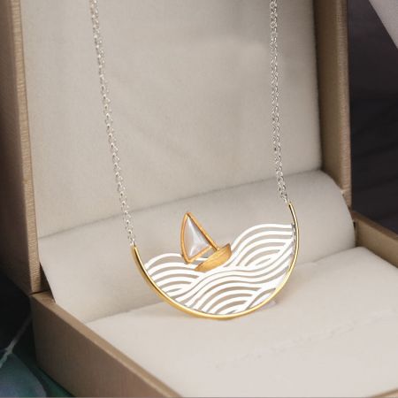 Collana a forma di veliero in argento sterling elegantemente presentata in una scatola di gioielli.