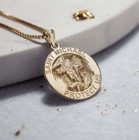 Ett guldhängehalsband som avbildar Sankt Mikael, en kraftfull symbol för skydd.