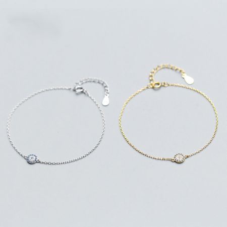 A pair of evil eye charm bracelets, one silver and one gold, displayed side-by-side.