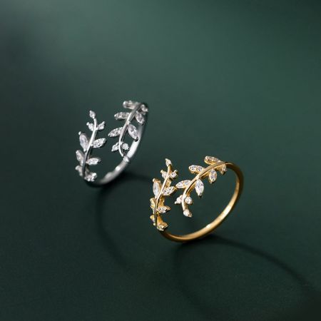 Set di 5 anelli regolabili a foglia in argento sterling 925 per donne - Un primo piano di due anelli a design a foglia in argento sterling 925, uno in finitura argento e l'altro in finitura oro, che mostrano i dettagli intricati e le gemme incastonate.