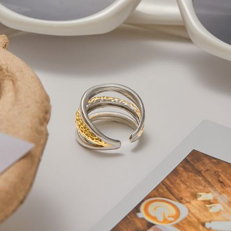 Gedetailleerd uitzicht op een meerlagige ring die zilveren en gouden tinten combineert voor een moderne uitstraling.
