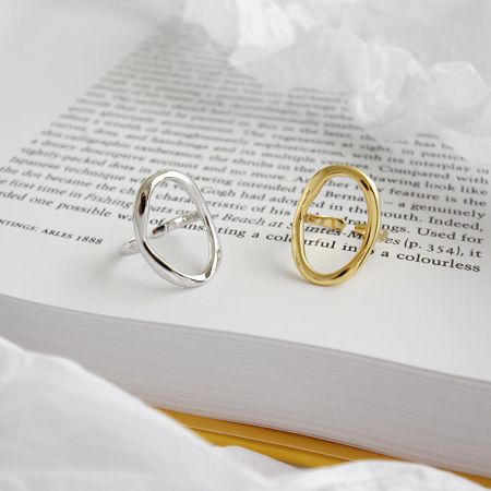 The 925 silver and 18K gold plated oval open rings displayed together on a book, highlighting the set.