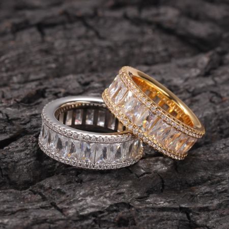 Anello baguette hip-hop bling ghiacciato - Anello Baguette Hip Hop Iced Out Bling mostrato nelle finiture argento e oro, ornato con pietre chiare taglio baguette.