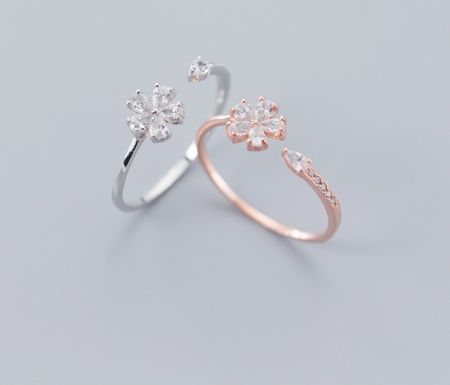 Bague fleur en argent sterling 925 - Une paire de bagues fleurs en argent sterling 925, l'une en argent et l'autre en or rose, toutes deux présentant des designs floraux complexes avec des pierres en zircon cubique étincelantes.