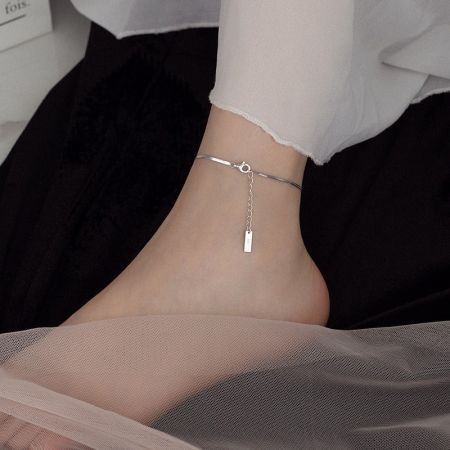 Close-up of the 925 silver snake chain anklet on a model's ankle, paired with sandals.