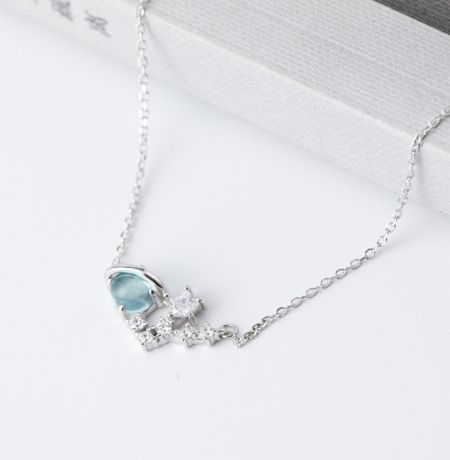Detailed view of a silver necklace featuring an elegant aquamarine and diamond pendant.