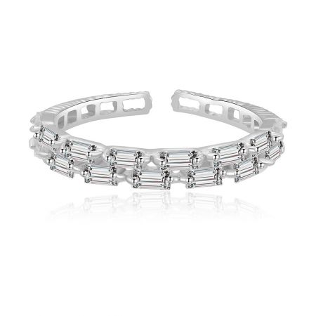 Bague délicate baguette en argent sterling - Une délicate bague baguette en argent sterling avec plaquage rhodium, présentant une rangée de pierres en zircon cubique étincelantes, présentée sur un fond blanc épuré.