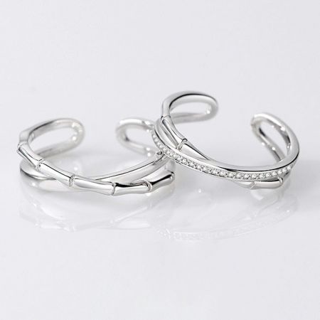 Detailed view of the bamboo-inspired silver rings, one plain and one with sparkling accents.