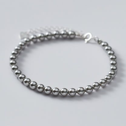 925 Sterling Zilveren 4mm Parelarmband - Een close-up studio-opname van de 925 Sterling Zilveren 4mm Parelarmband, die zijn fijne kralen en metallic glans toont.