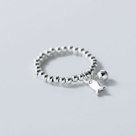 Scatto ravvicinato dell'anello con pendente a forma di pesce in argento sterling 925, evidenziando l'artigianato.