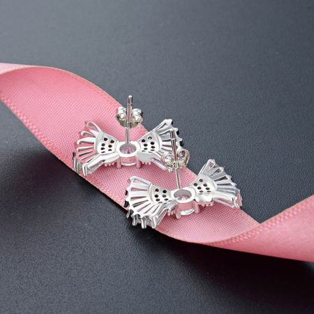 Vista posteriore degli orecchini a bottone a forma di fiocco in argento sterling, che mostrano il perno e il retro.