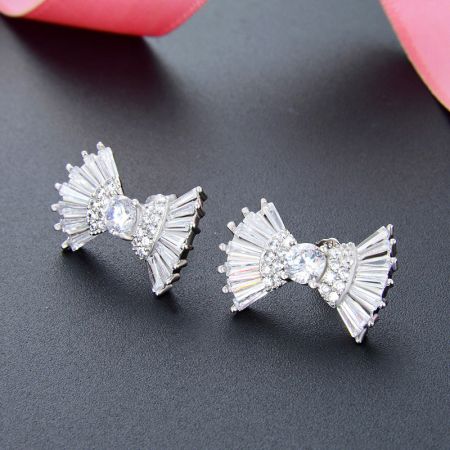 925 Sterling Zilveren Zirconia Lint Strikstud Oorbellen (Set van 5 Paar) - Een paar 925 sterling zilveren lint strikstud oorbellen versierd met sprankelende heldere zirconia kristallen, weergegeven op een donkergrijze achtergrond.
