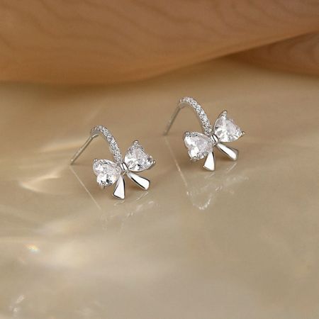 중앙 보석과 복잡한 디자인을 강조한 스털링 실버 리본 귀걸이의 상세 샷.