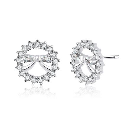 Détail en gros plan de la boucle d'oreille en forme de nœud mini rond, soulignant la finition plaquée rhodium et l'halo de pierres précieuses en zircon cubique transparent.