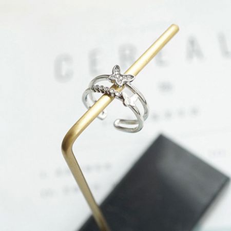 Un anillo de diseño de lazo de plata con una piedra central clara, parte del conjunto de anillos ajustables.