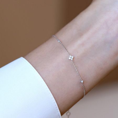 A sterling silver bracelet from the set, featuring intricate floral details for a classic style.