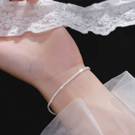 عرض مقرب لسوار التنس الفضي على معصم، يبرز تصميمه الدقيق والأنيق.