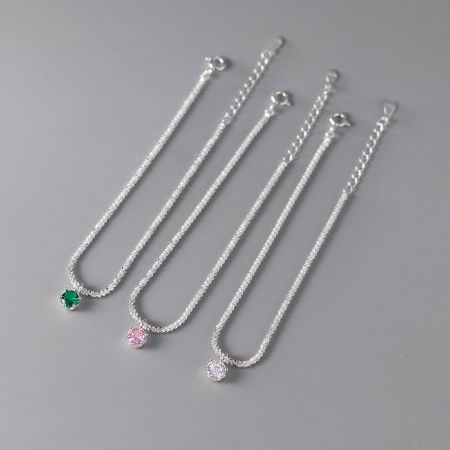 도매 세트에서 온 네 개의 925 실버 팔찌, 각각 다른 색상의 지르콘 보석이 특징이며 깨끗한 흰색 배경에 전시되어 있습니다.