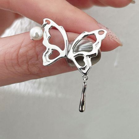 Orecchini a goccia asimmetrica in argento sterling 925 con perla a forma di farfalla punk liquida (5 paia) - Primo piano di un orecchino a forma di farfalla in argento sterling 925 con un delicato accento di perla, parte del set di orecchini a goccia liquida punk asimmetrica.