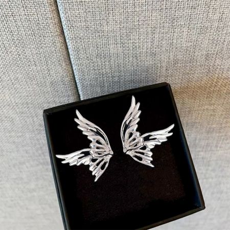 Il set di orecchini a bottone a forma di farfalla placcati in argento presentato in una elegante scatola nera per gioielli.