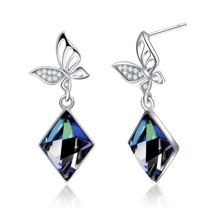 Boucle d'oreille pendante en cristal de papillon en argent sterling 925 - Gros plan sur des boucles d'oreilles pendantes en argent sterling 925 en forme de papillon, avec des ailes en pierre claire complexes et de grands cristaux Swarovski bleus facettés.