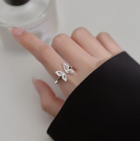 Bague en argent sterling 925 en forme de papillon - Un gros plan d'une main portant la bague papillon en argent sterling 925, mettant en valeur son design détaillé de papillon et ses accents en zircon cubique étincelants.