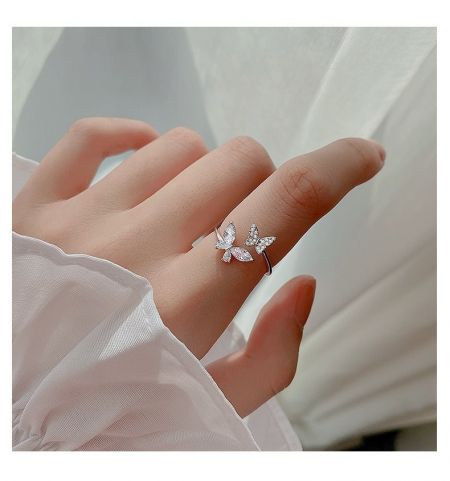 Anillo de mariposa de zirconia cúbica de plata 925 minimalista estilizado en la mano de un modelo.