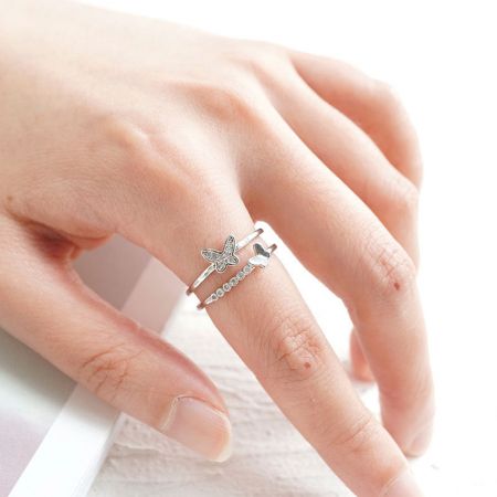 Un anillo de mariposa de plata esterlina del conjunto usado en un dedo para mostrar la escala y el ajuste.