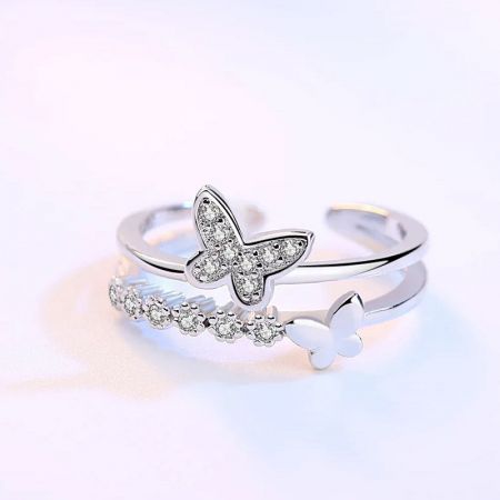Dos anillos de motivo de mariposa diferentes de la colección de plata esterlina exhibidos juntos.